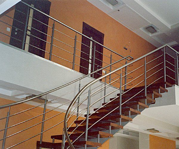 A staircase with a stainless steel railing and wooden steps