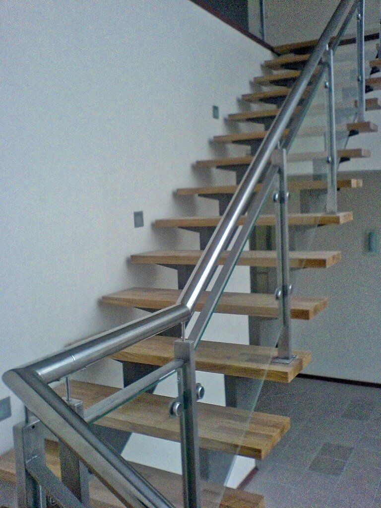 A staircase with wooden steps and a stainless steel railing