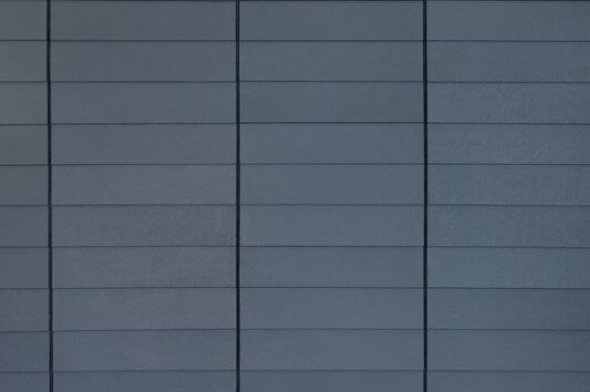 A close up of a gray wall with a grid pattern.