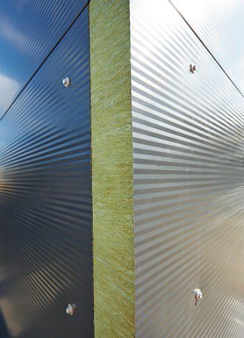 A close up of a metal wall with screws on it.