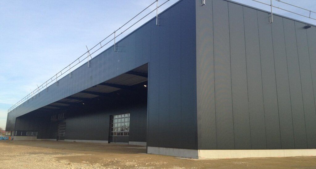 A large black building with a lot of windows is under construction.