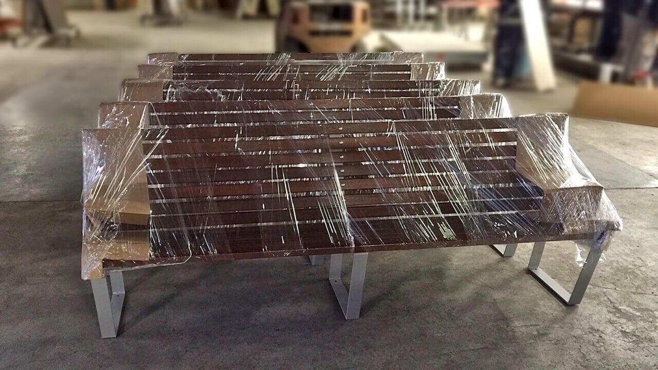 A row of wooden benches wrapped in plastic