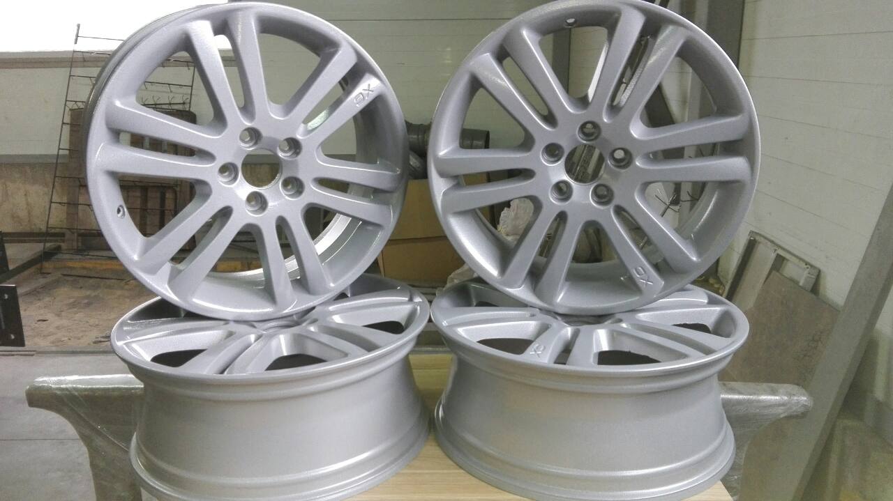 A pair of silver wheels are sitting on top of a wooden table.