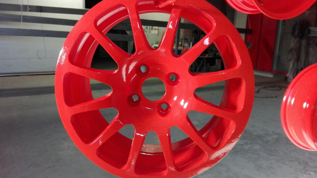 A close up of a red wheel with a hole in the middle