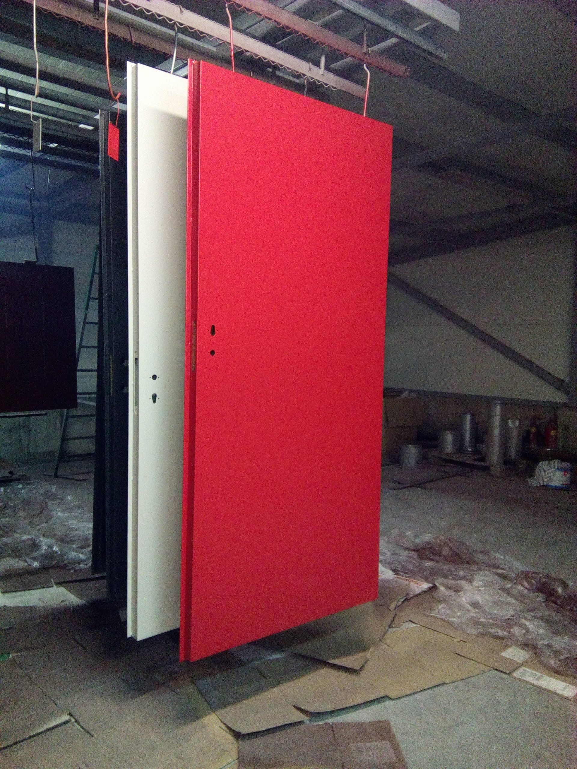 A red white and black door in a warehouse