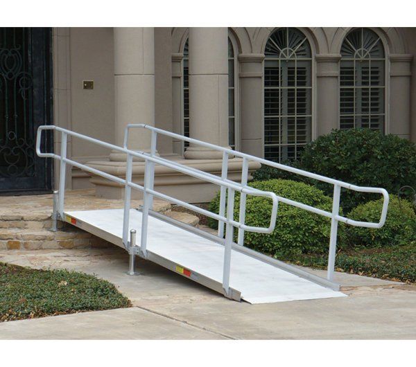 A ramp with a railing is in front of a house