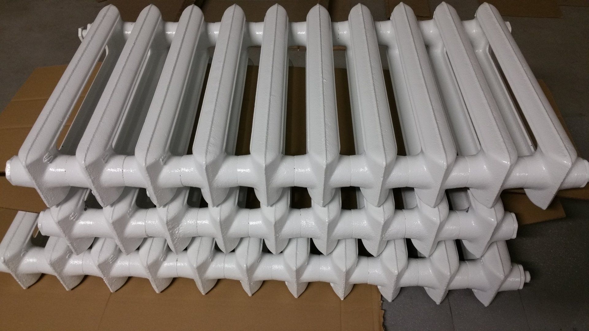 A bunch of white radiators are stacked on top of each other