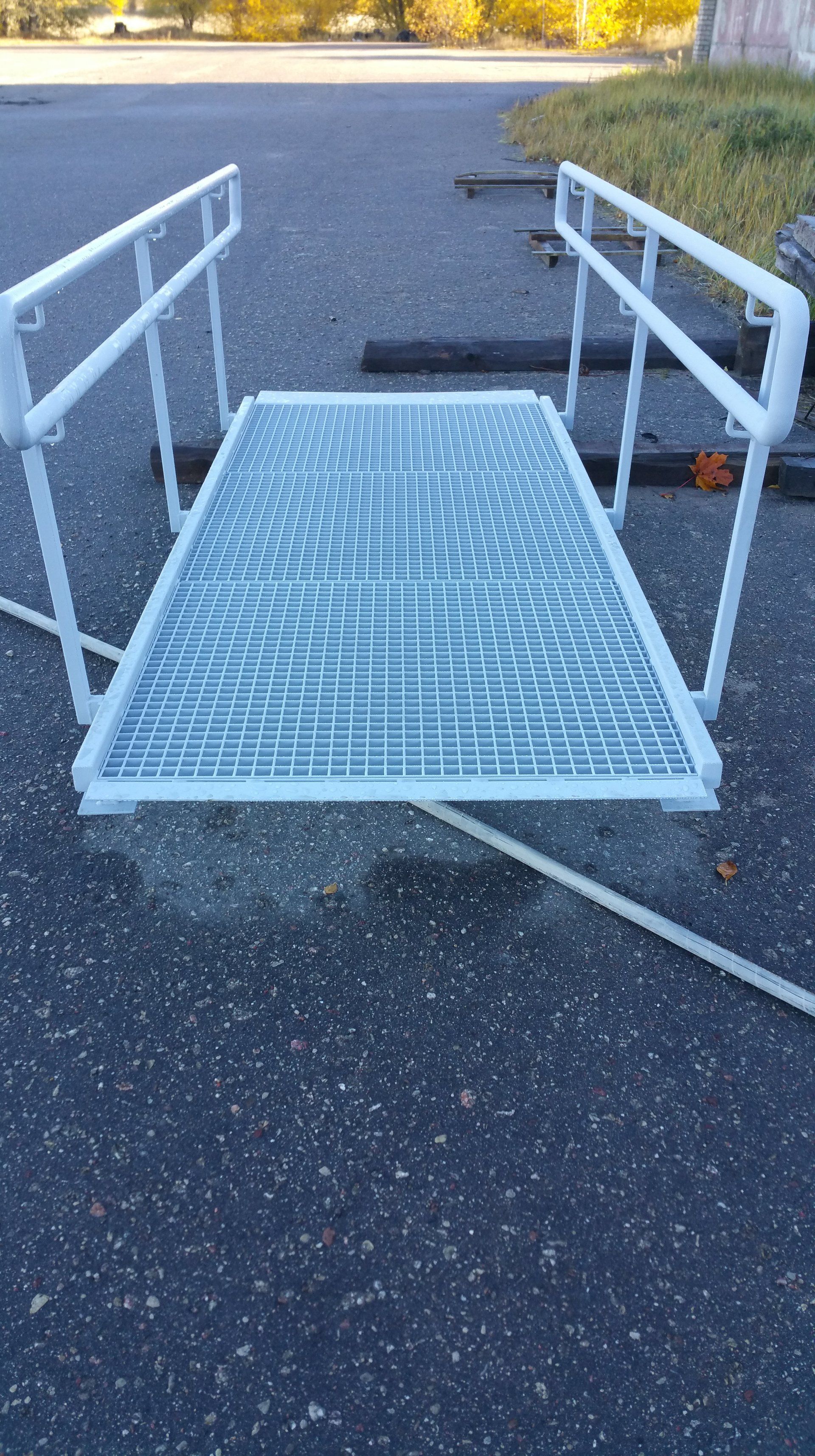 A metal ramp is sitting on the side of a road.