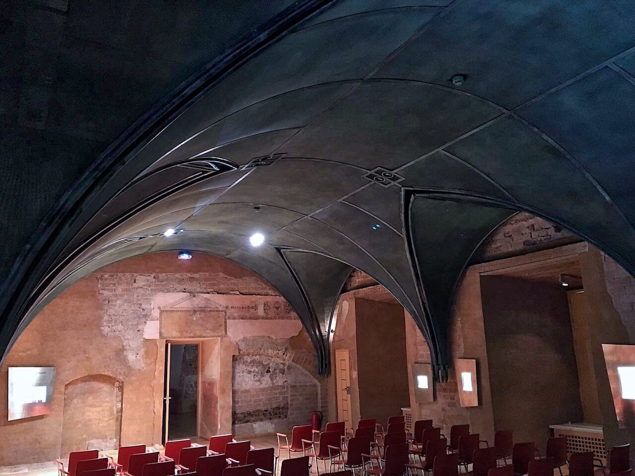 A large room with arched ceilings and rows of chairs