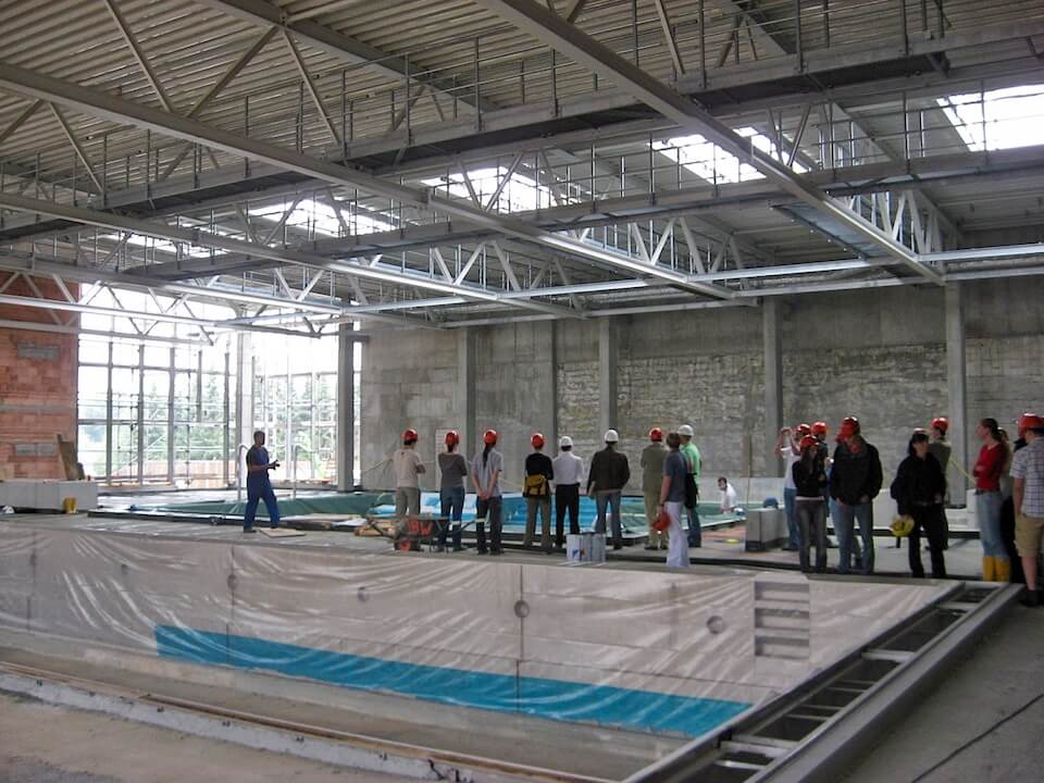 A group of people are standing in a building under construction