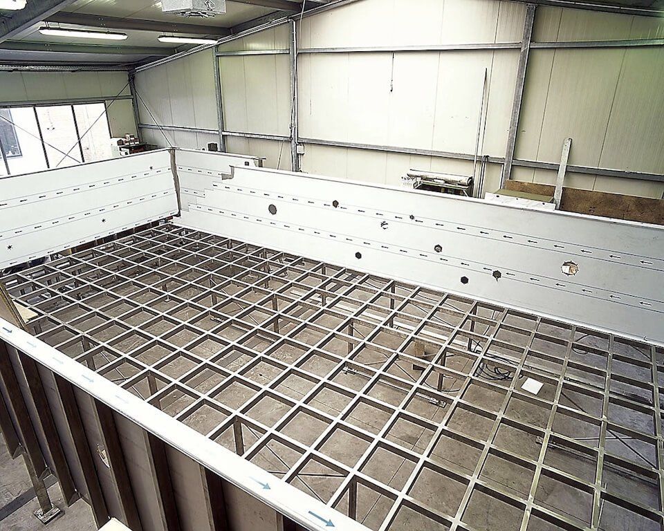 A large metal structure is being built inside of a building