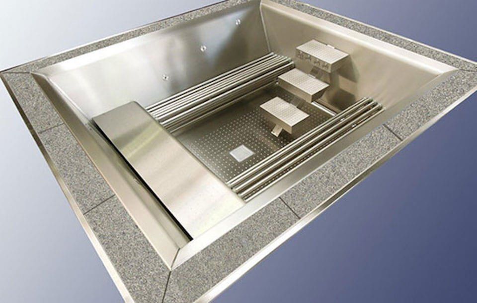 A stainless steel bathtub with steps in it
