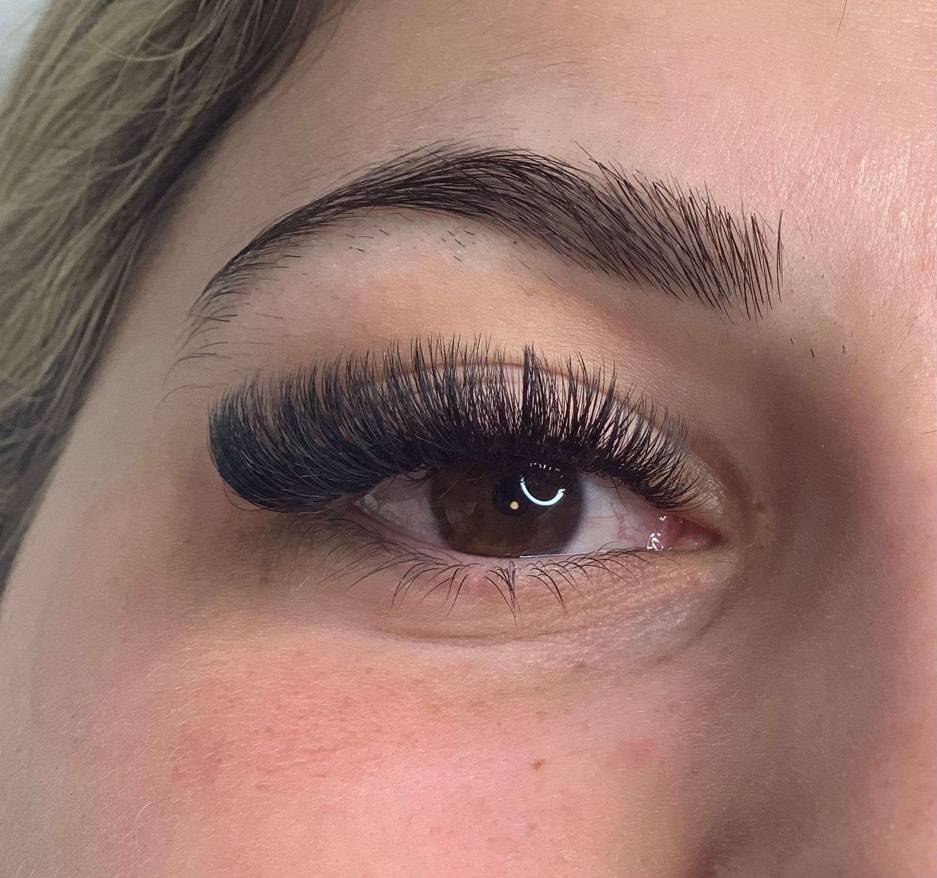 Eine Nahaufnahme des Auges einer Frau mit langen Wimpern.