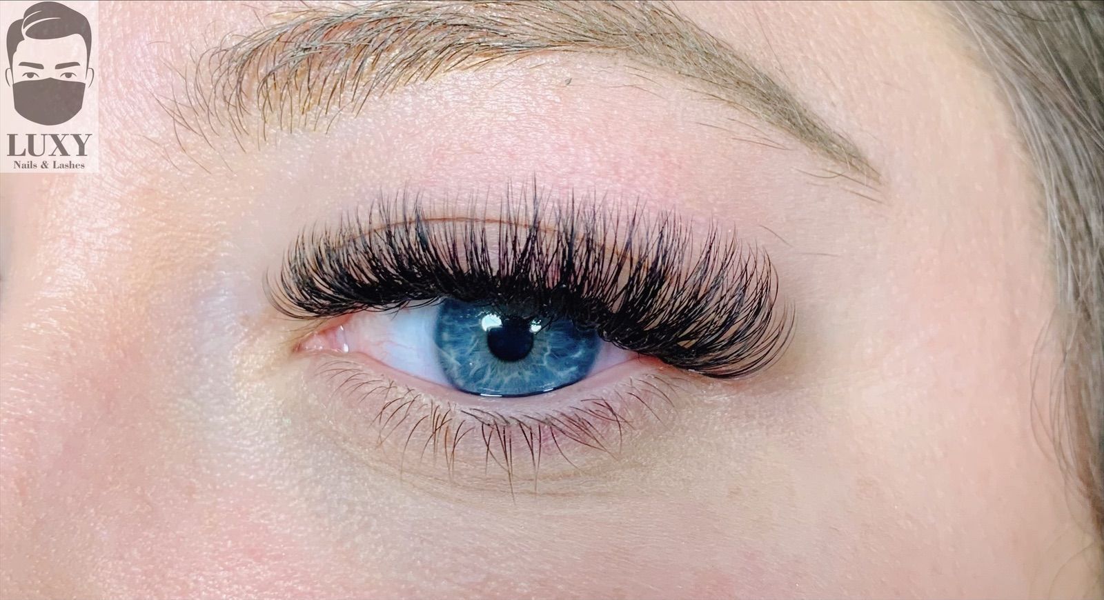 Eine Nahaufnahme des Auges einer Frau mit langen Wimpern.