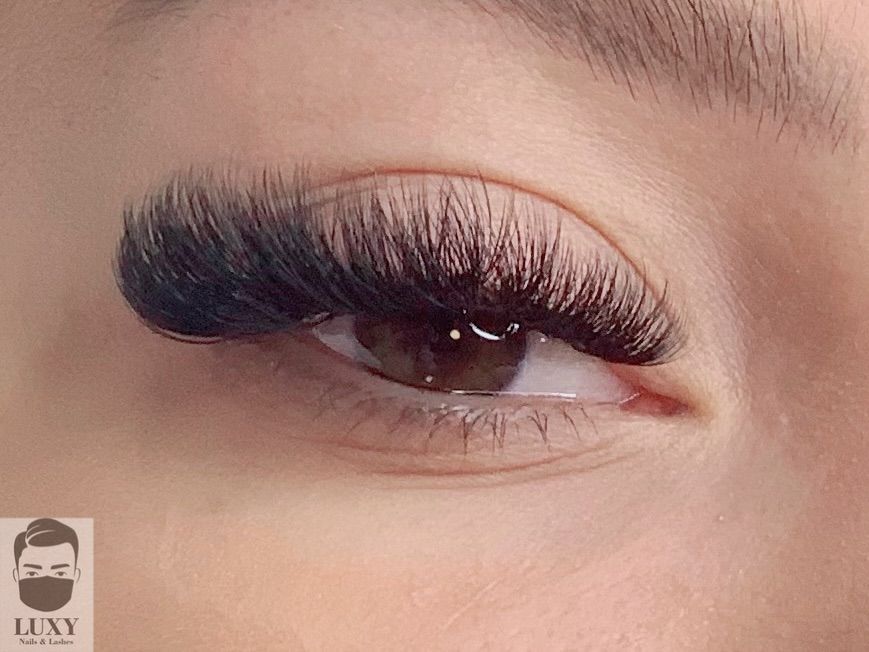 Eine Nahaufnahme des Auges einer Frau mit langen Wimpern.