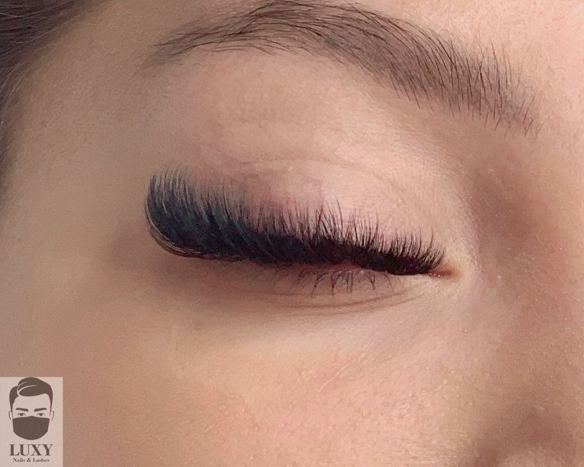 Eine Nahaufnahme des Auges einer Frau mit langen Wimpern.