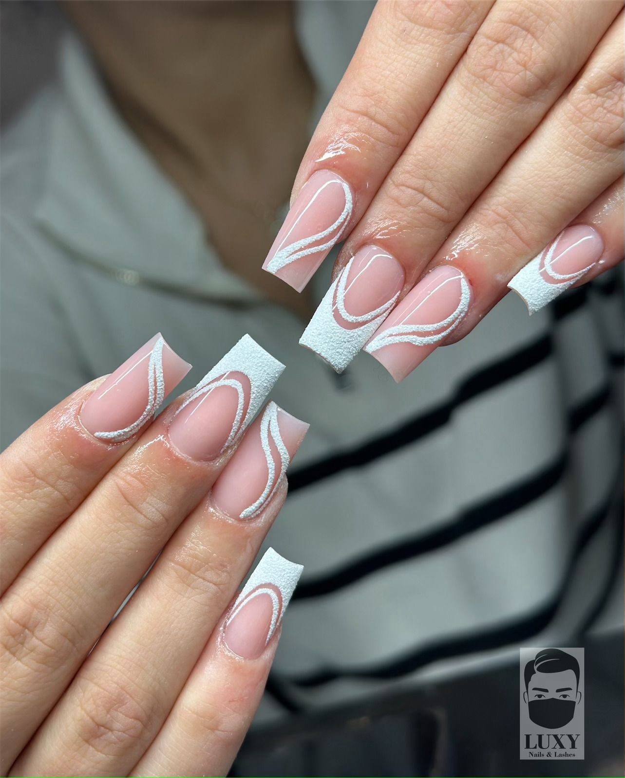 Eine Nahaufnahme der Nägel einer Frau mit einer French Manicure