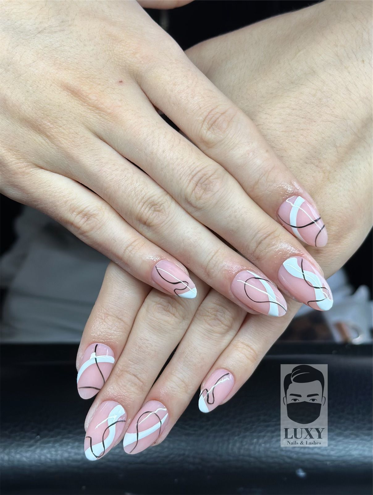 Eine Nahaufnahme der Nägel einer Frau mit einem Muster darauf.