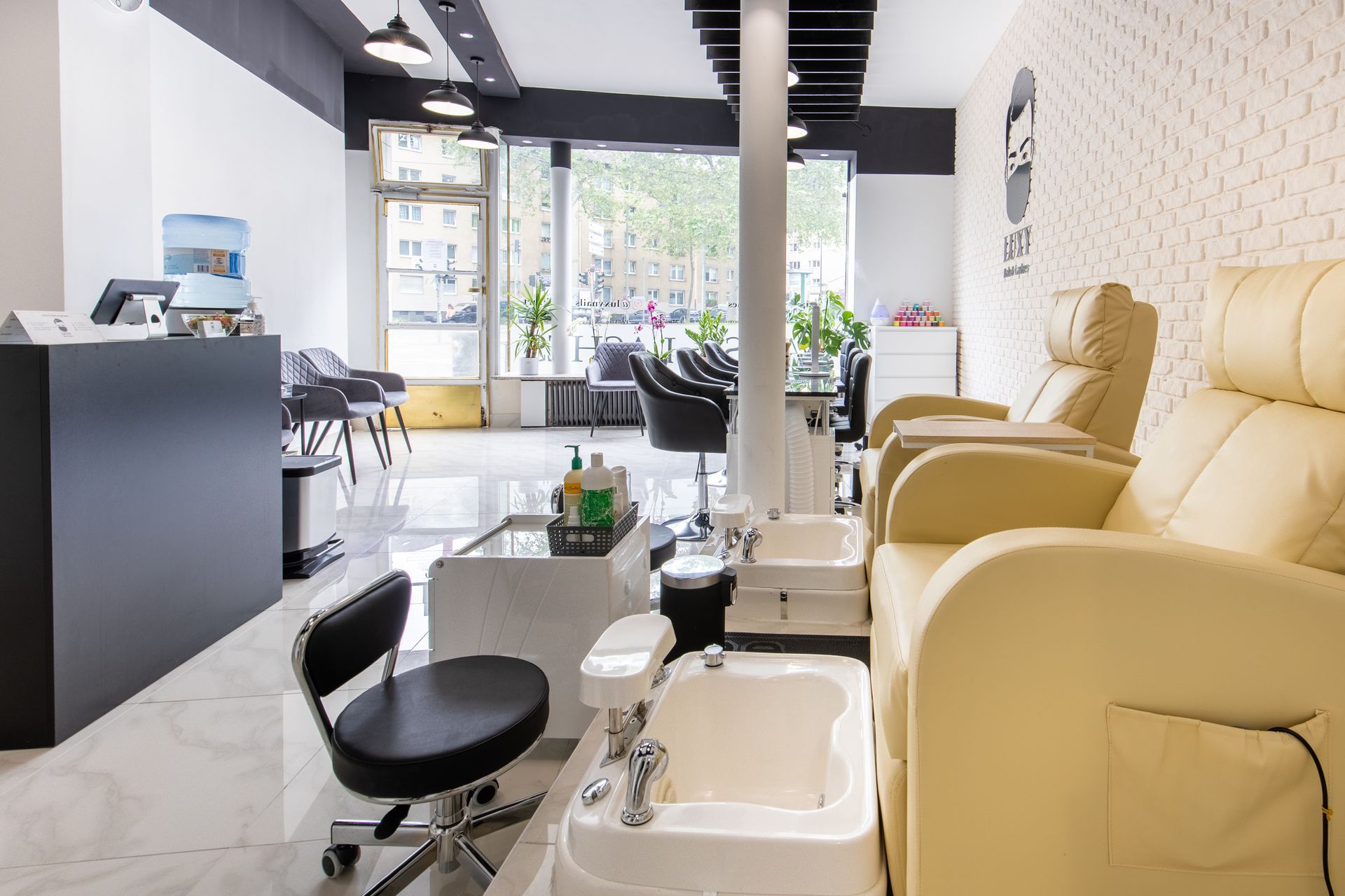 Ein Nagelstudio mit vielen Stühlen und Waschbecken.