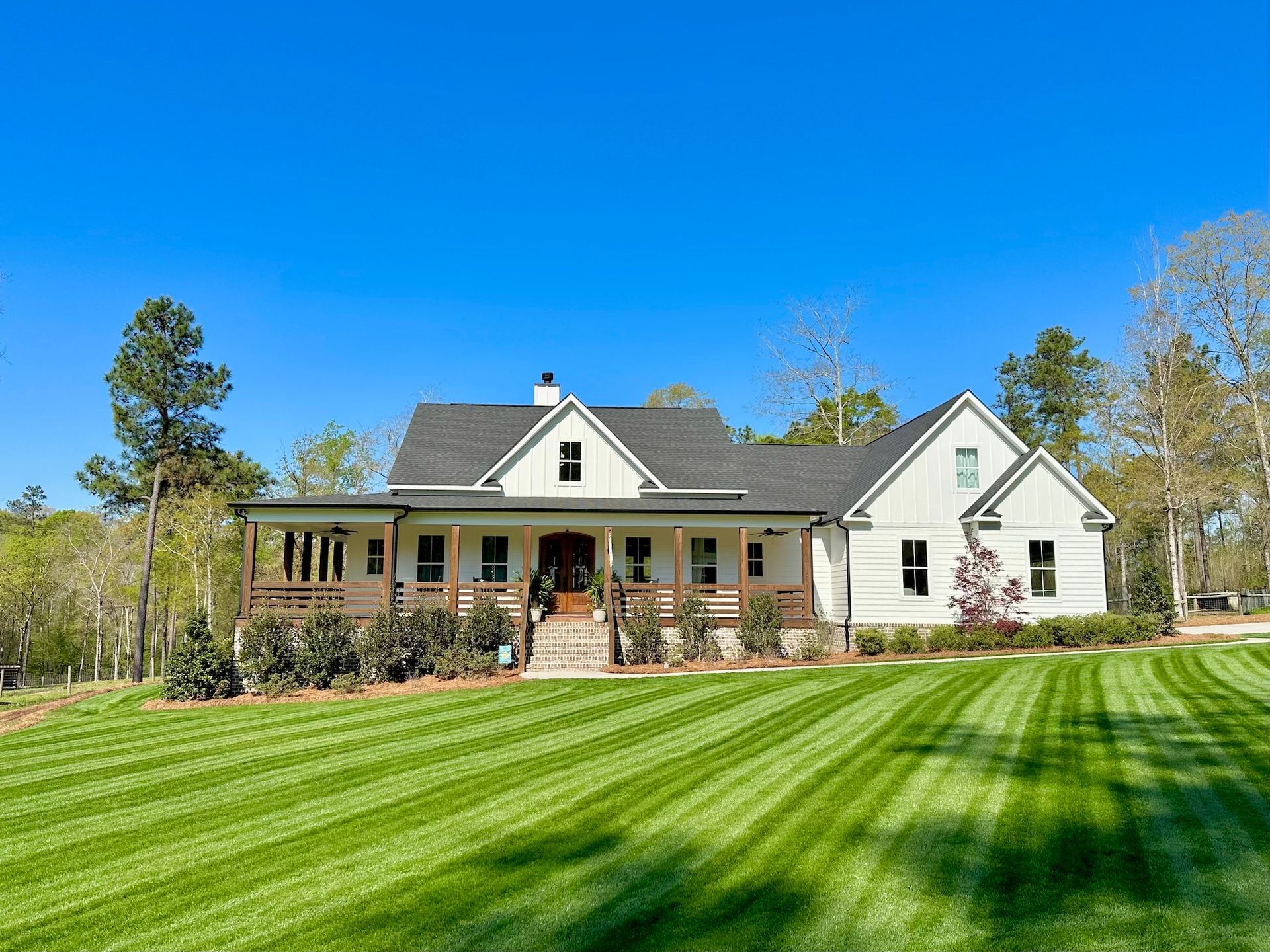A large white house with a large lawn in front of it.