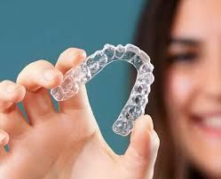 A woman is holding a clear brace in her hand.