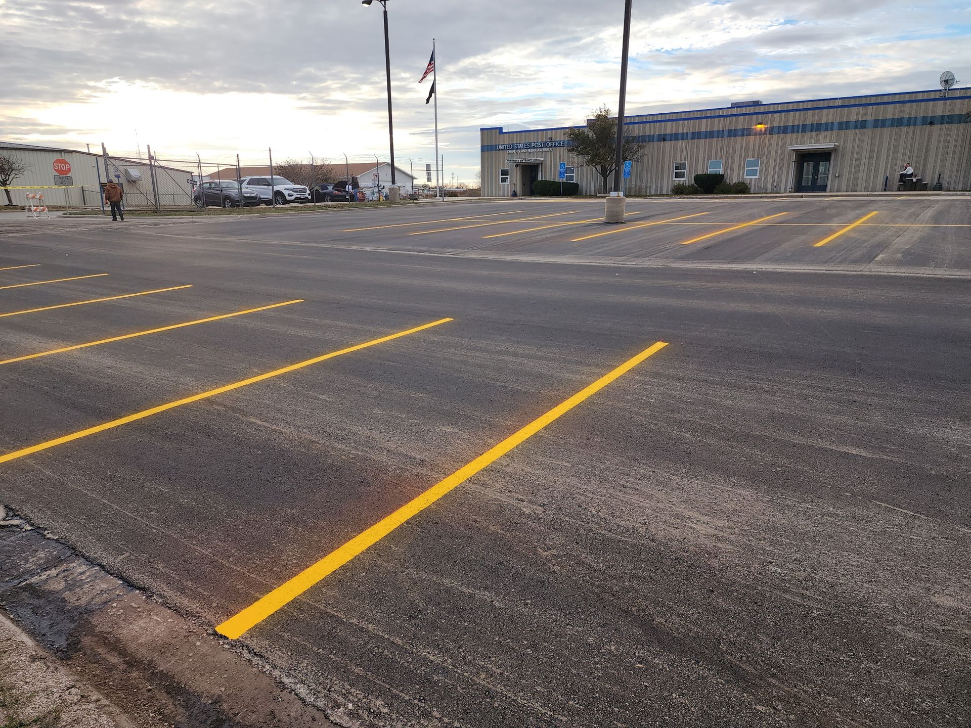 Parking lot with fresh yellow lines and a commercial building in the background.