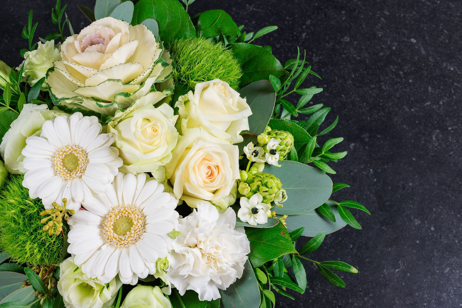 An elderly couple is sitting at a table with a laptop and a notebook.