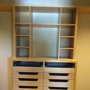 Light wood built-in closet with drawers and shelves.