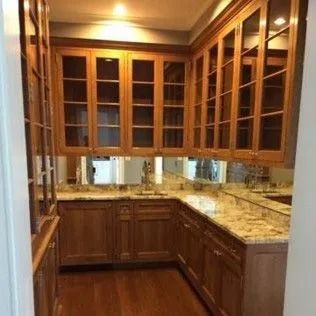 Butler's pantry with wood cabinets, glass-front doors, and granite countertops.
