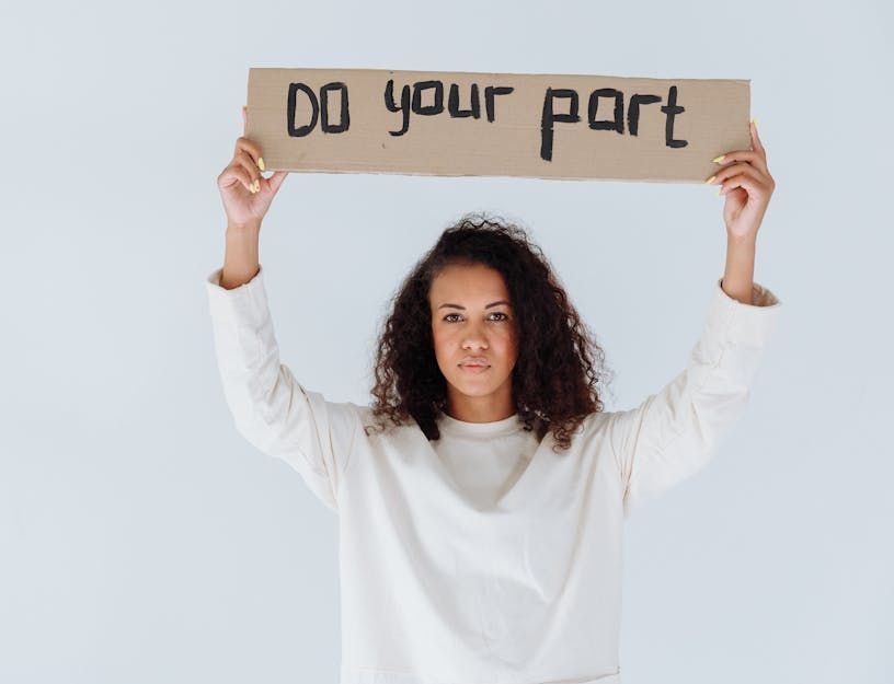A woman is holding a sign that says `` do your part ''.