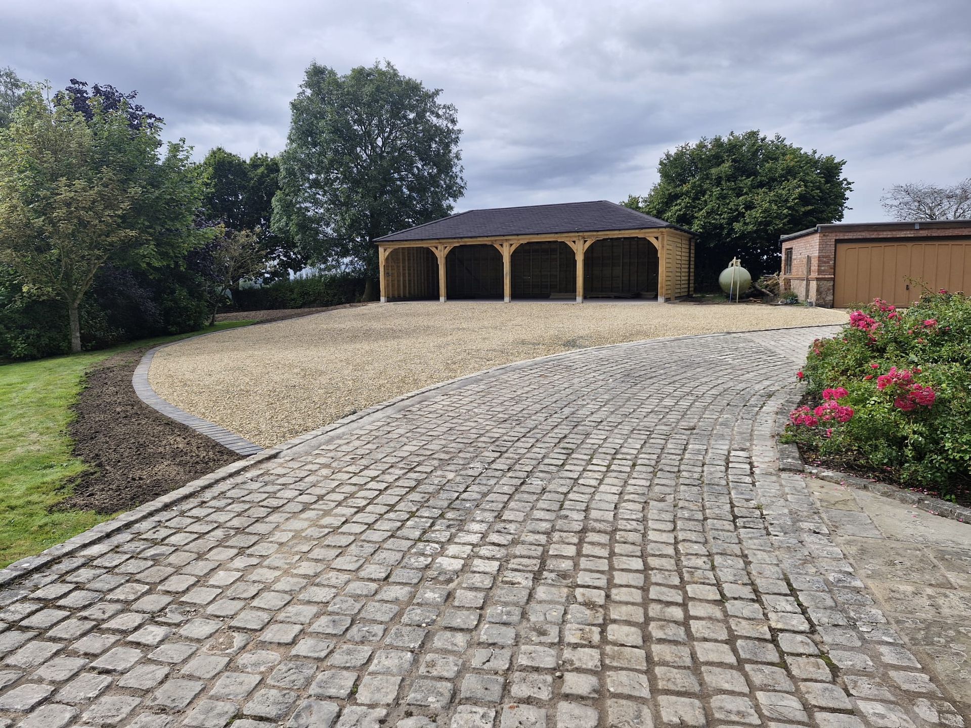 Paved driveway in Shrewsbury with open wood garage