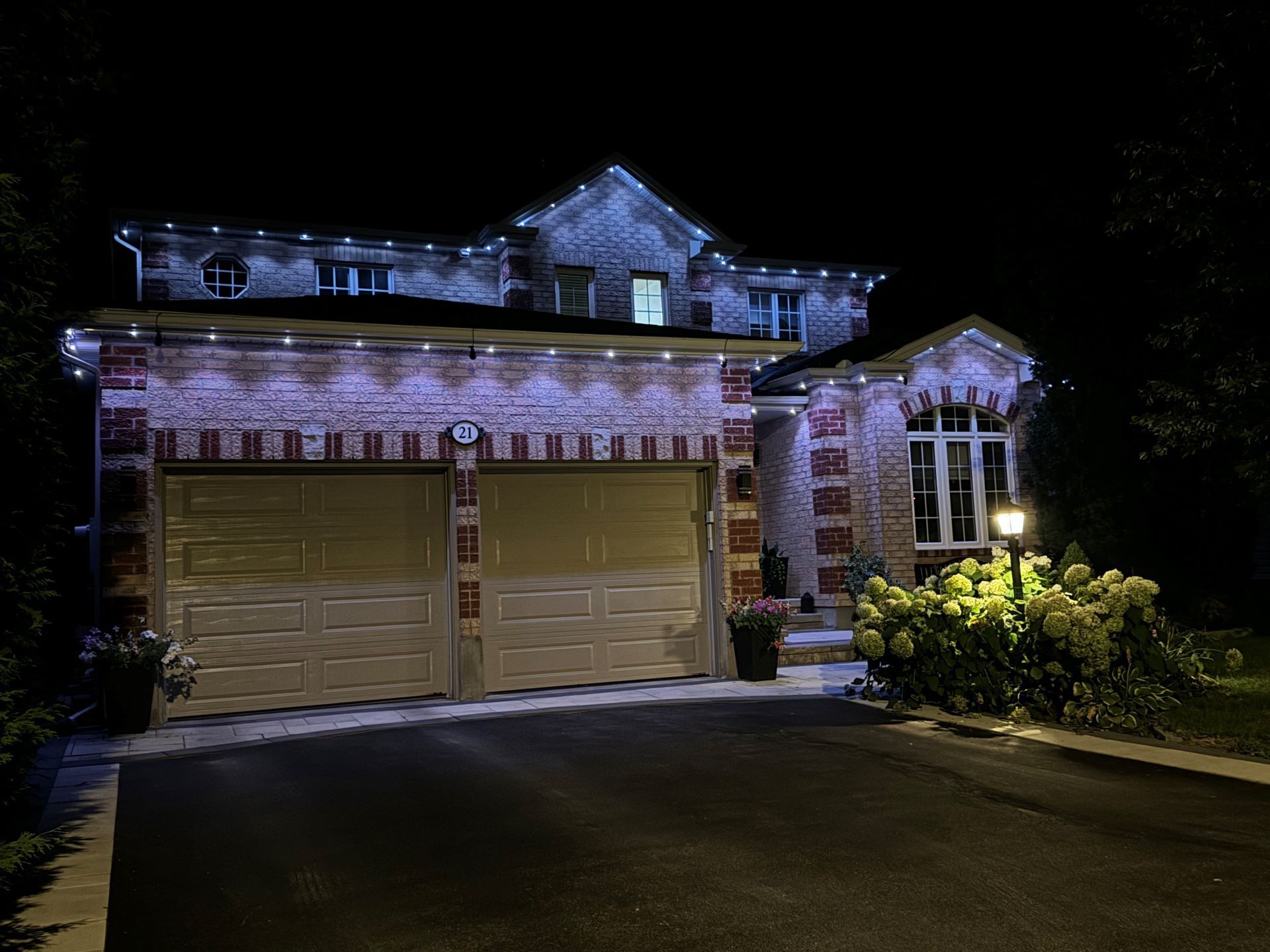 A house with christmas lights on it is lit up at night.