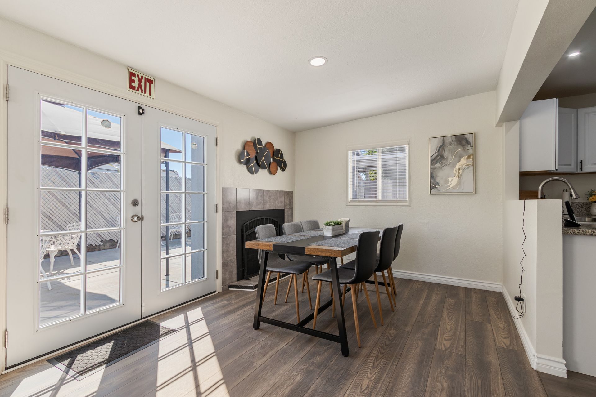Dining room with table, chairs, fireplace, and glass doors leading to a patio.