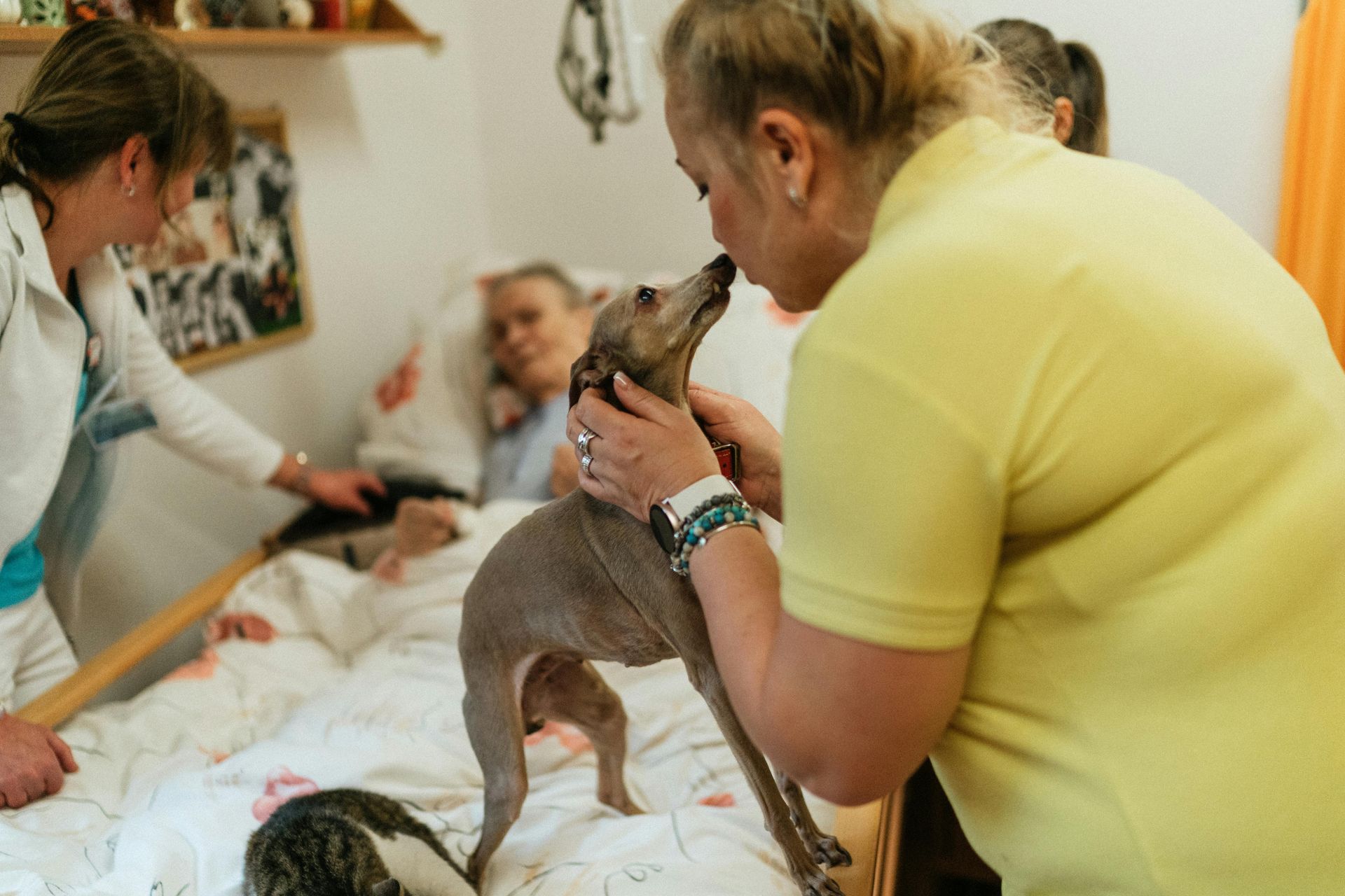 Woman kissing a dog, elderly patient in bed. A Helping Hand Home Care in Lancaster, CA.