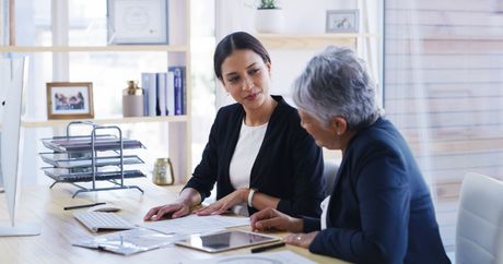 A lawyer is talking to an elderly woman.