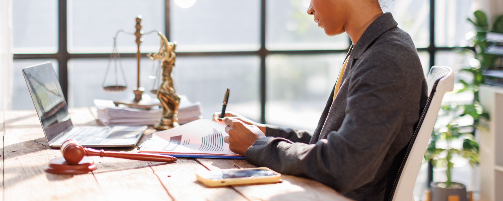 Probate services attorney reviewing legal documents at desk with scales of justice icon. Probate services attorney reviewing legal documents at desk with scales of justice icon.