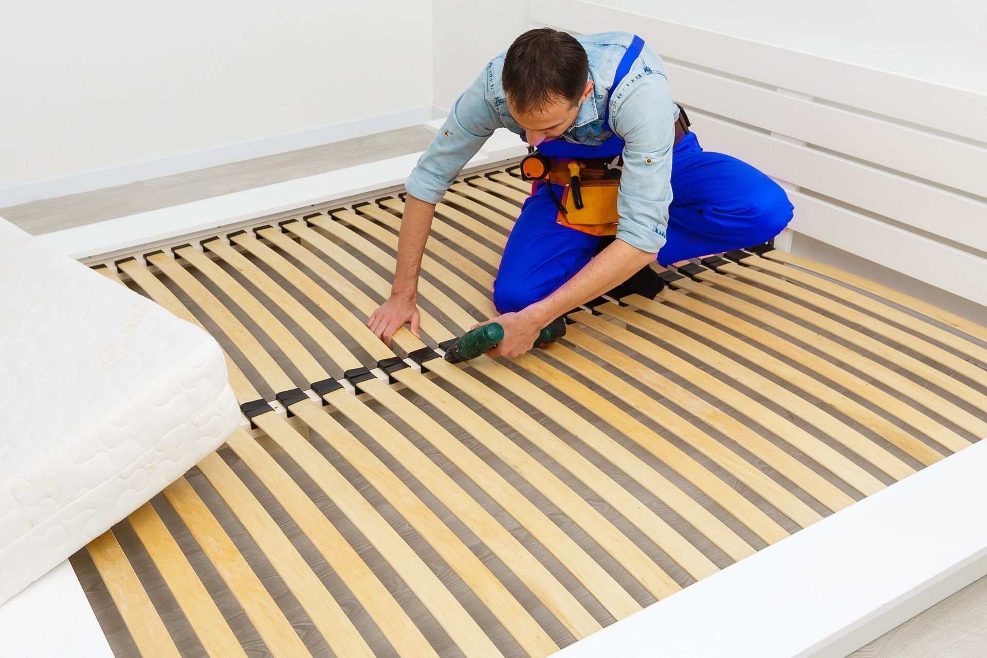 Worker installing underfloor heating mats on a floor frame