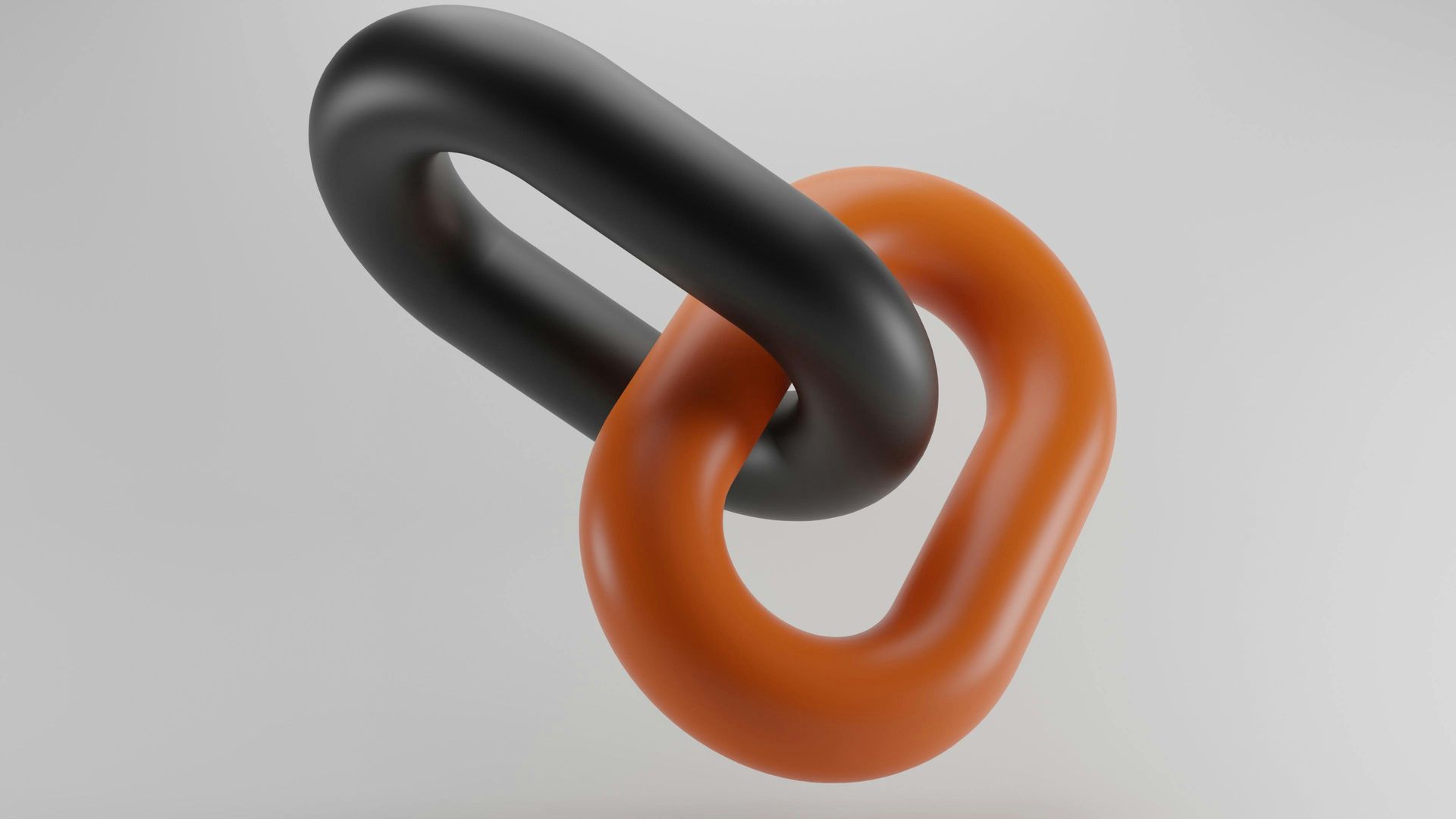Two interlocking chain links, one black and one orange, isolated on a light gray background.