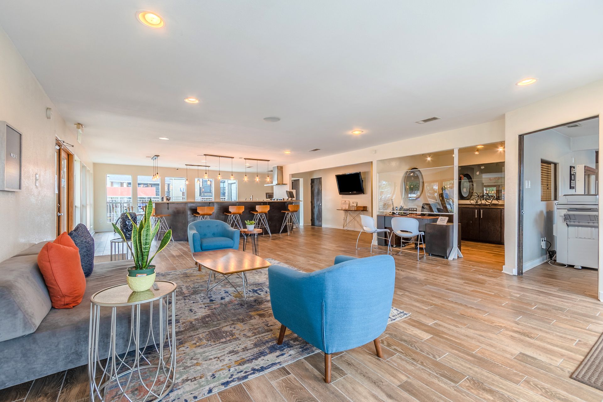 Photo of the community clubhouse lounge showing a living room type of area with a barstool area in the background