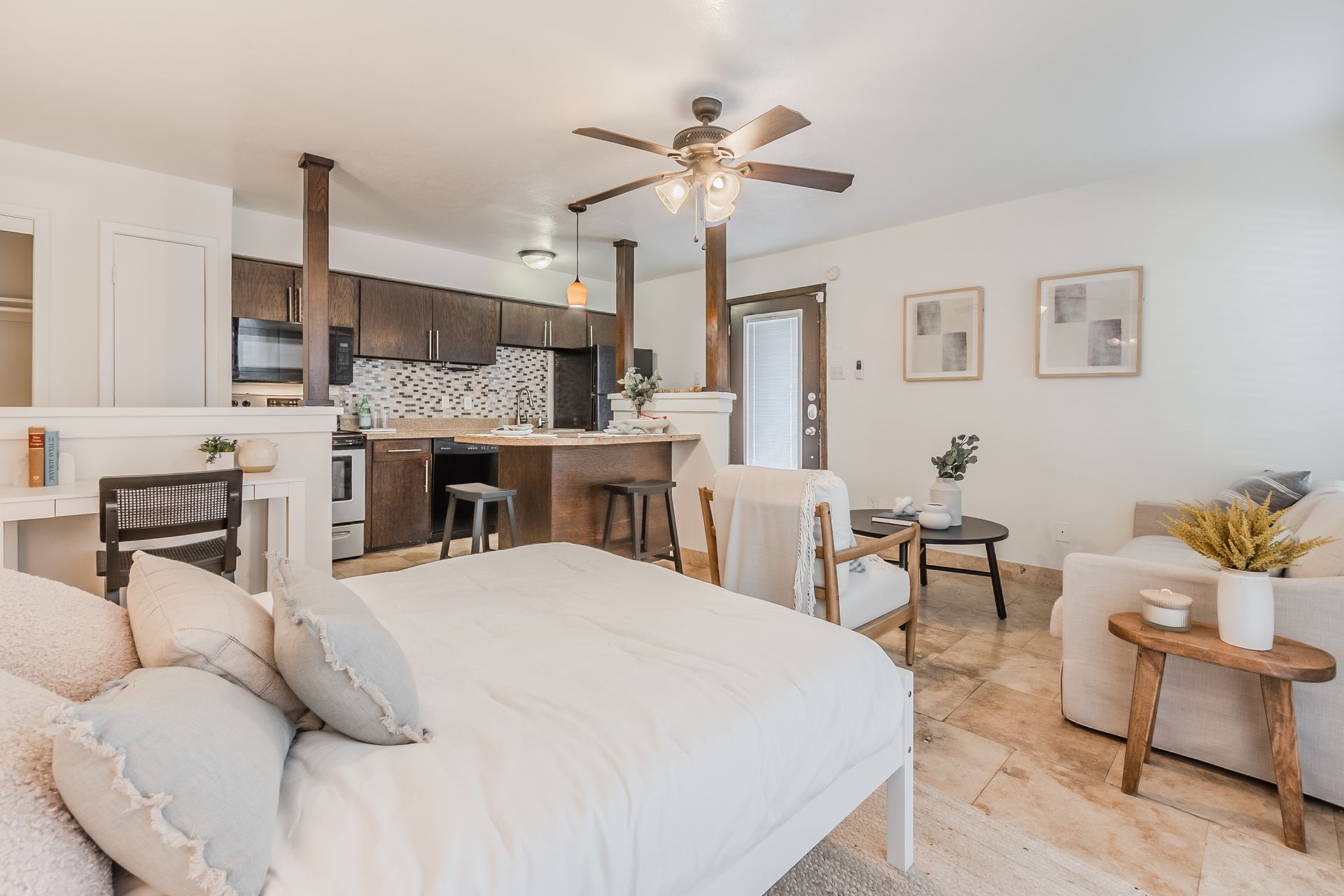 Photo of a studio floor plan, showing a bed with the kitchen in the background