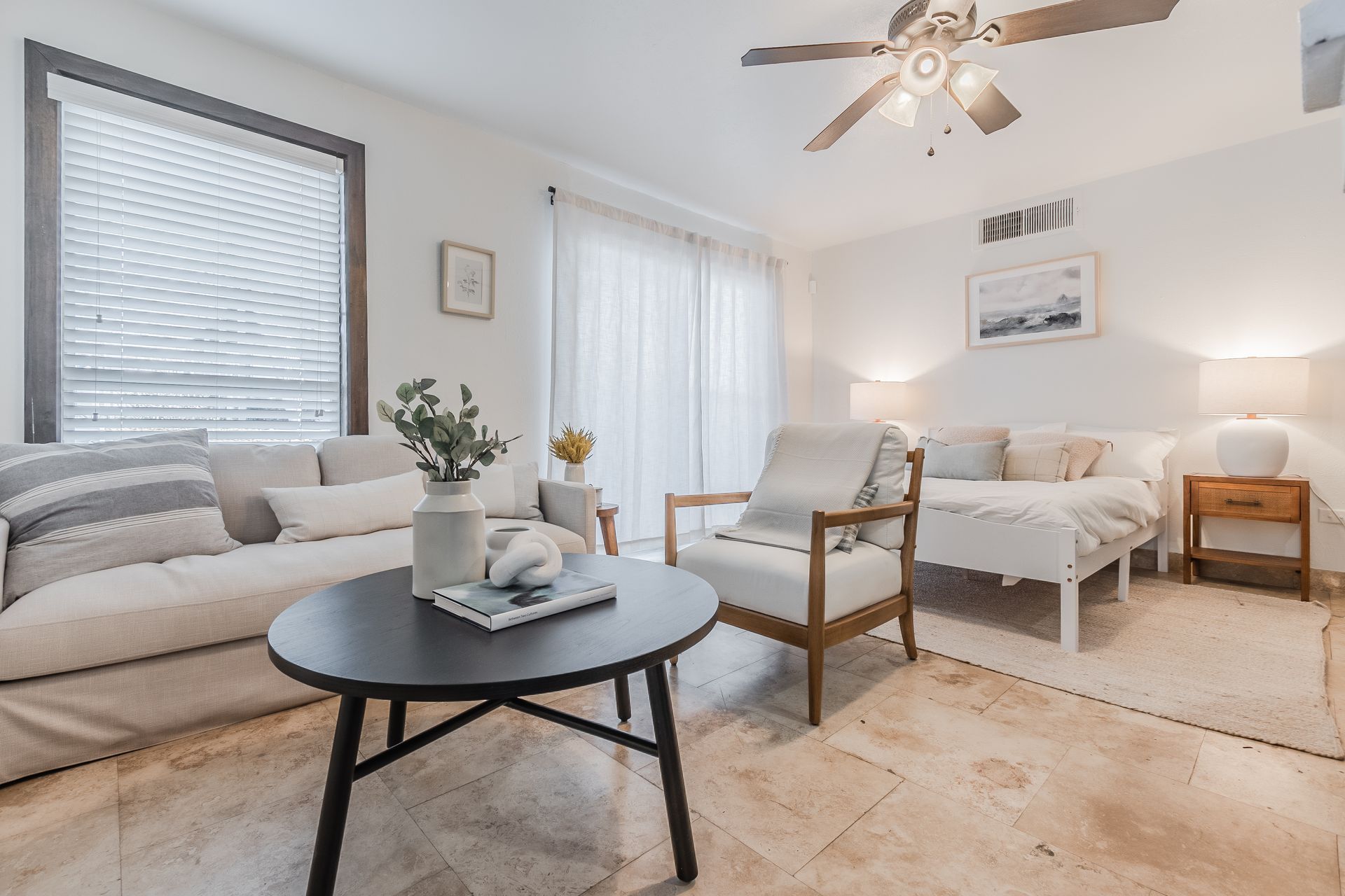 Photo of a living room table and sitting area with the sleeping area in the background