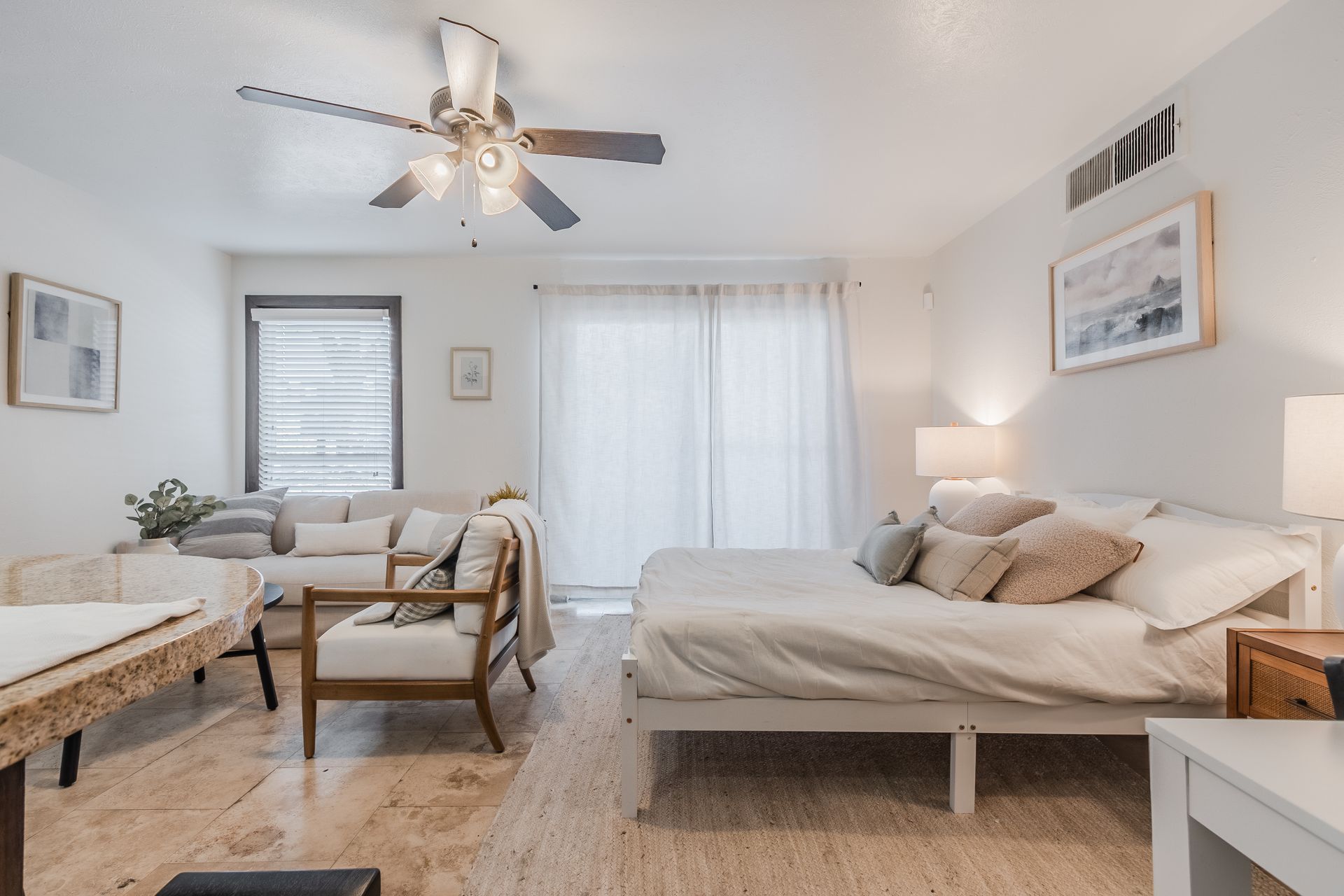 Photo of a living room area with a bed behind it