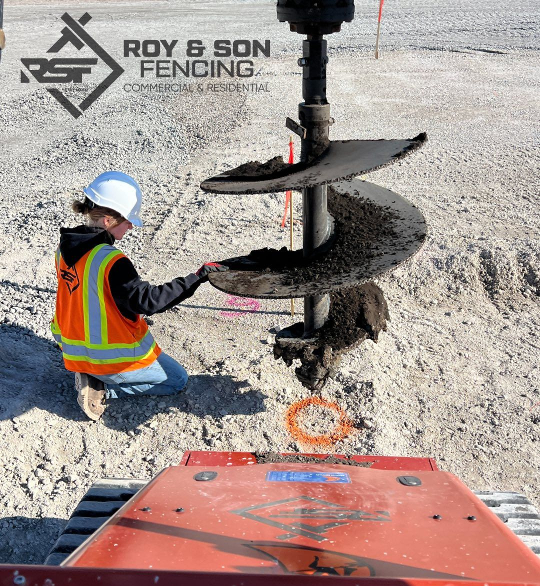 A person in safety gear inspecting an auger drill on a construction site.