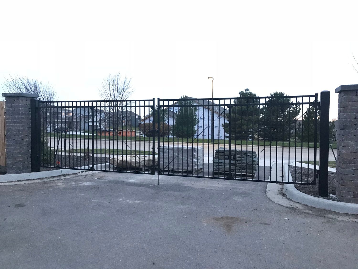 Black metal security gate set between brick columns.