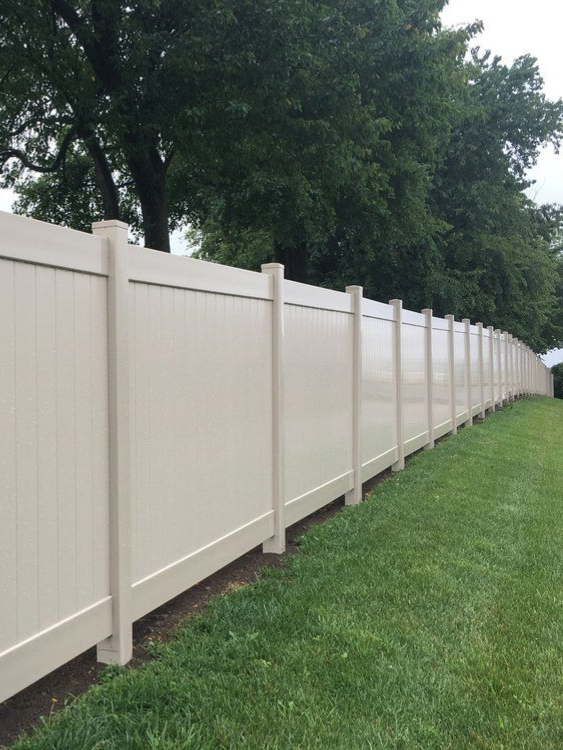 white vinyl fence corner enclosing a square area with vertical planks.