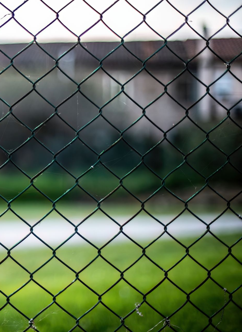 Chain link fence corner section, metallic gray.