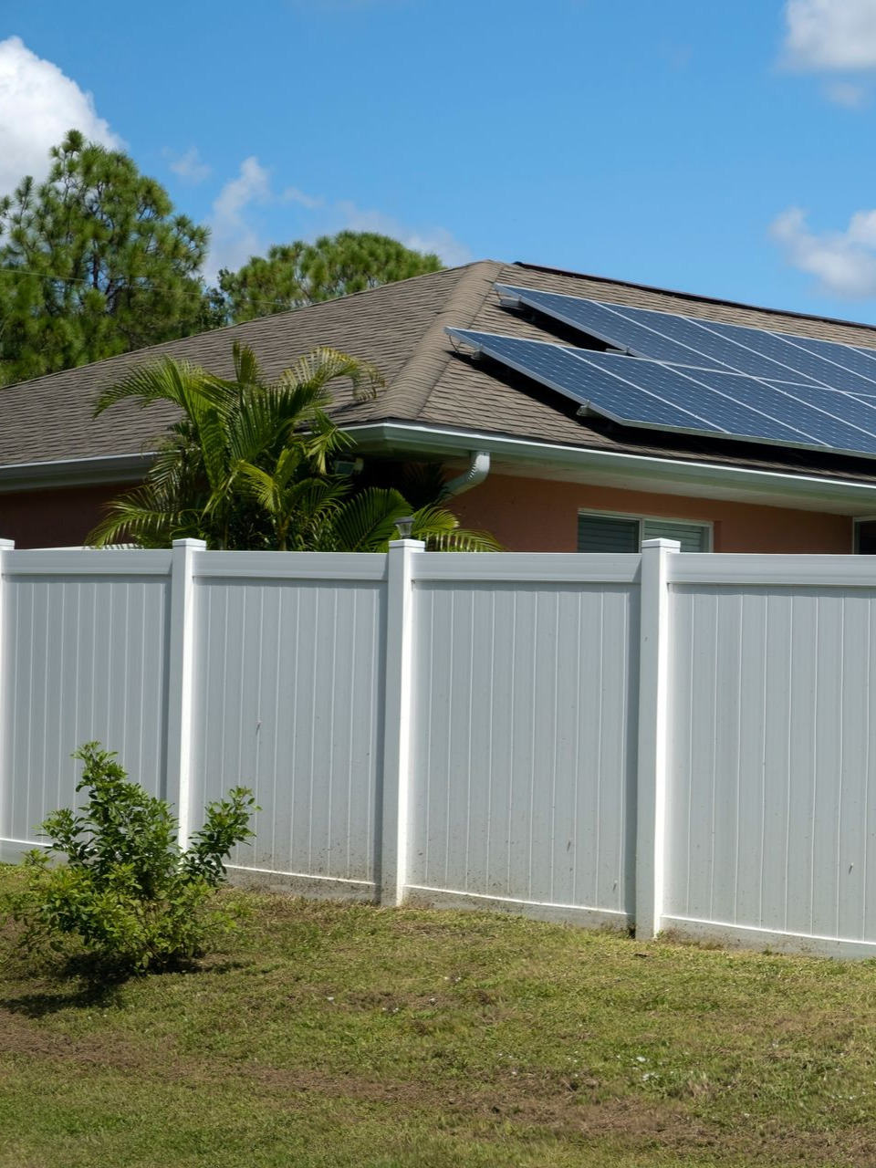 white vinyl fence corner enclosing a square area with vertical planks.
