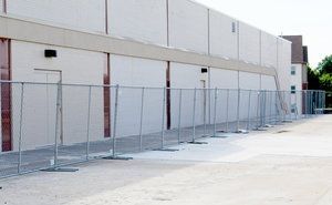 Chain-link fence set up next to a light-colored building.