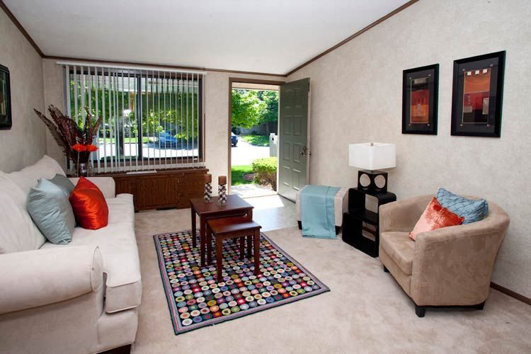 A living room with a couch and chairs and a rug