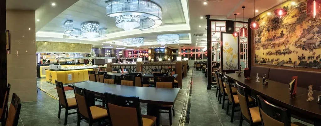 ein großer Essbereich mit Tischen und Stühlen in einem Restaurant .